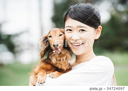 犬を抱く若い日本人女性の写真素材