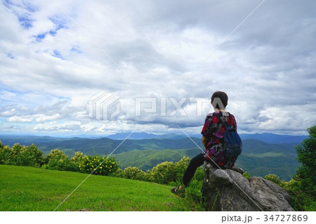 Woman sitting on the rock and looking at the view  34727869