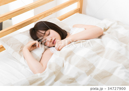 ベッドで眠る若い女性 34727900