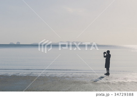 silhouette man take a photo on the beach silhouette man take a photo on the beach 34729388