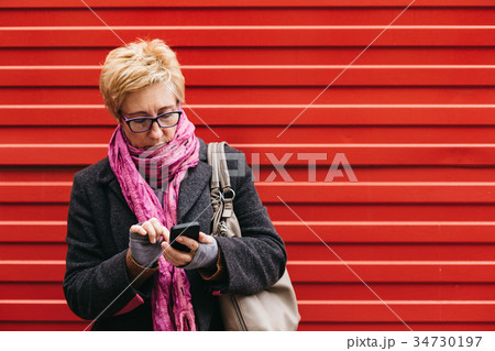 Adult woman with smartphone on street 34730197