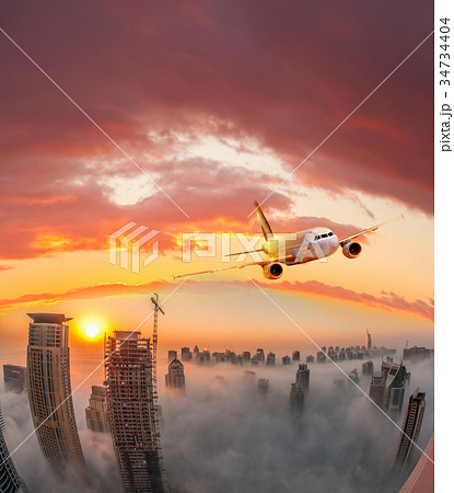 Plane is flying over Dubai in United Arab Emirates Plane is flying over Dubai in United Arab Emirates 34734404