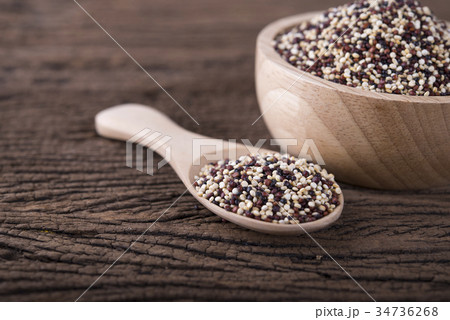 dry tricolor quinoa in wooden spoon and bowl 34736268