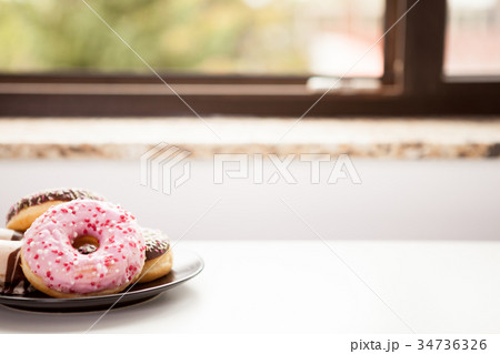 Plate with donuts next to window Plate with donuts next to window 34736326
