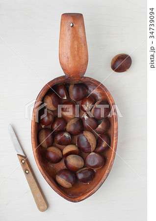 Fresh raw chestnuts in the wooden plate 34739094