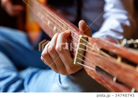 young woman playing guitar 34740743