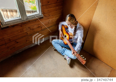 young woman playing guitar 34740744