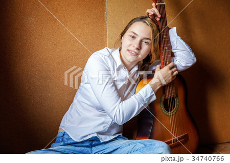 young woman playing guitar 34740766
