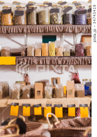 Glass cans with many dried spices plants is standing on shelf Glass cans with many dried spices plants is standing on shelf 34743419