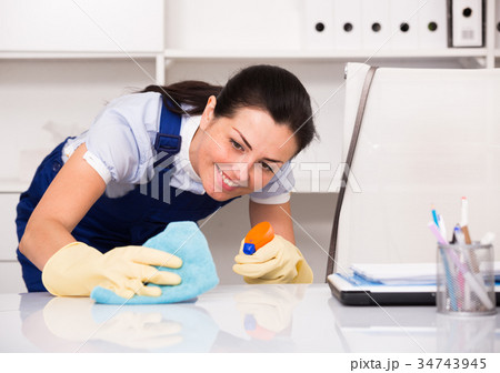 female cleaning furniture with rag 34743945