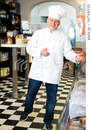 Male seller posing with wursts in butchery 34744018