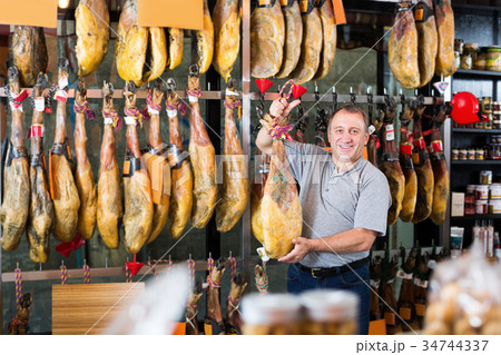 Elderly man buying tasty jamon leg in store 34744337