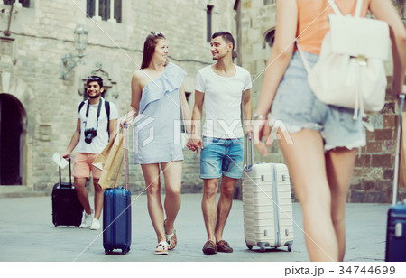 Smiling couple in shorts with luggage Smiling couple in shorts with luggage 34744699