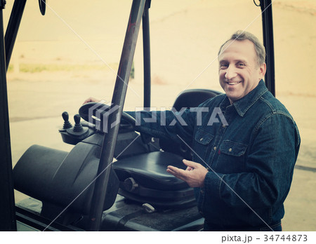 Worker goes driving loader 34744873