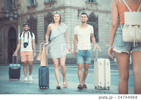 Cheerful man and woman in shorts with luggage 34744968