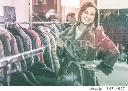 Girl choosing sheepskin coat Girl choosing sheepskin coat 34744997