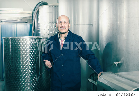 mature man working in wine fermentation section. 34745137