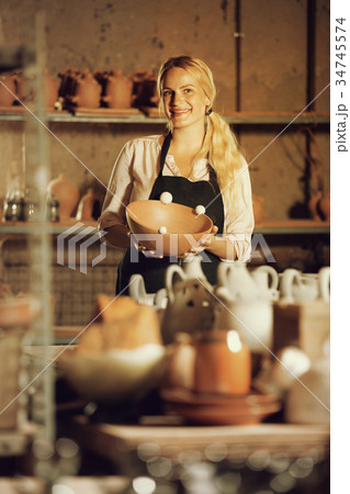 Female potter in apron in atelier. 34745574