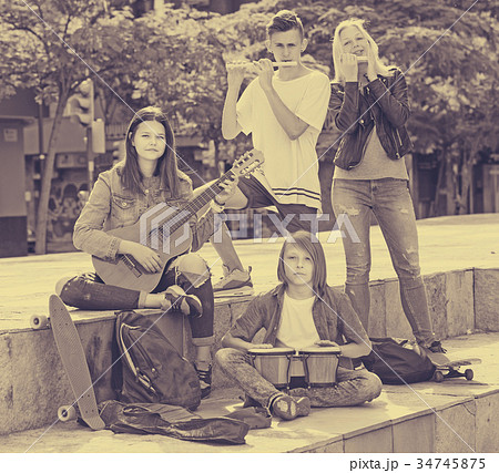 Group of happy teenagers musicians in park 34745875