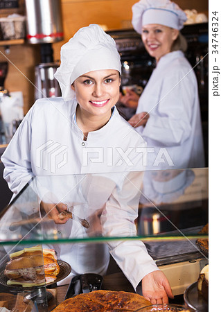Cafe staff offering cakes 34746324
