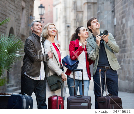 Two couples with baggage sightseeing and smiling Two couples with baggage sightseeing and smiling 34746631