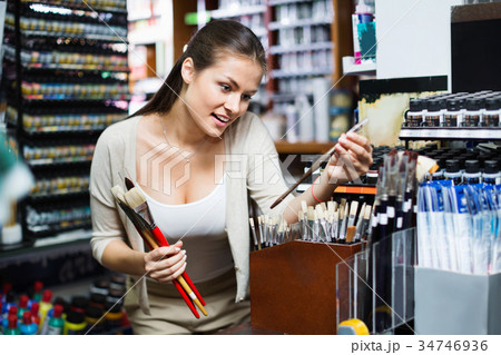 Portrait of cheerful woman choosing brushes for drawing 34746936