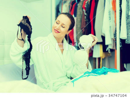 Woman choosing bra at bedroom 34747104