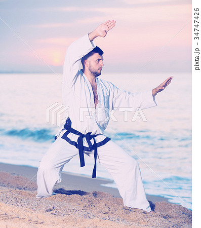 Happy man doing karate at ocean quay 34747426