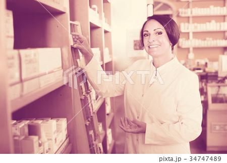Smiling mature woman seller in drugstore Smiling mature woman seller in drugstore 34747489