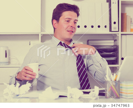 Worker relaxing in office at the table Worker relaxing in office at the table 34747963