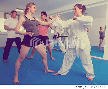 Adults are practicing new karate moves in pairs 34748433