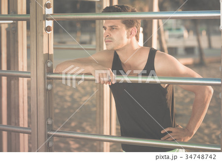 Man in sportswear near fitness station 34748742