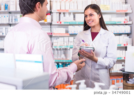 Pharmacist and customer in drugstore . Pharmacist and customer in drugstore . 34749001