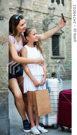 Woman with little daughter traveling together, taking selfie 34749031
