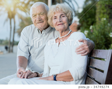 couple of male and female sitting on bench couple of male and female sitting on bench 34749274