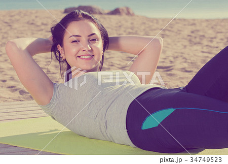 girl doing workout on beach in sunny morning girl doing workout on beach in sunny morning 34749523