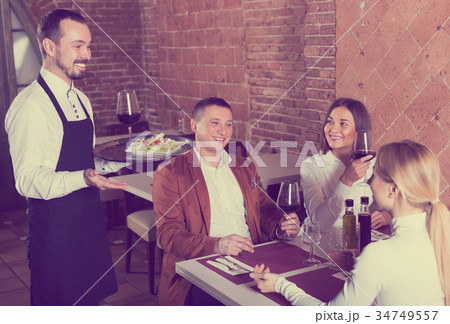Male waiter carrying order for visitors Male waiter carrying order for visitors 34749557
