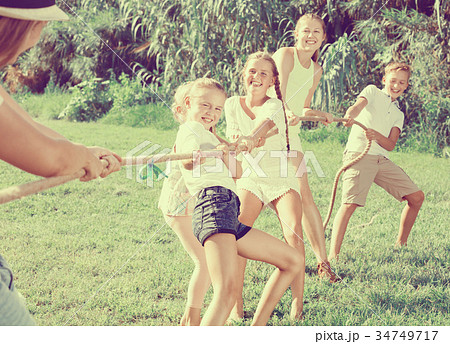 Children with moms and dads playing tug of war Children with moms and dads playing tug of war 34749717