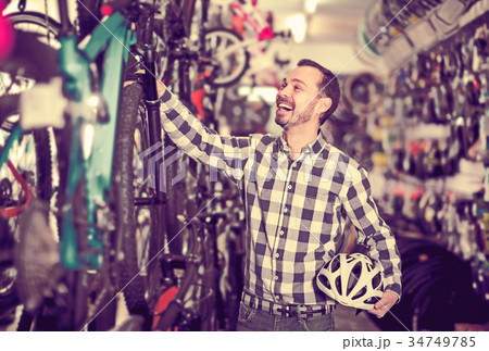Man selects bicycle in sporting goods store 34749785