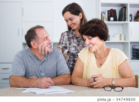 Daughter helping her senior parents to do paperwork 34749830