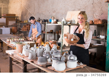 two potters working with ceramics in atelier. two potters working with ceramics in atelier. 34750269