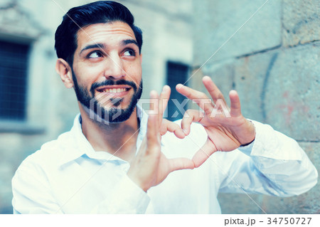 Passionate man making heart with finger 34750727