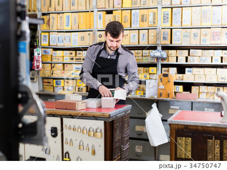 Man seller sorting boxes with door details Man seller sorting boxes with door details 34750747