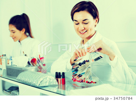 Female manicurist showing lacquer color schemes 34750784