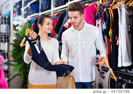 Couple choosing new sportswear in sports store 34750786