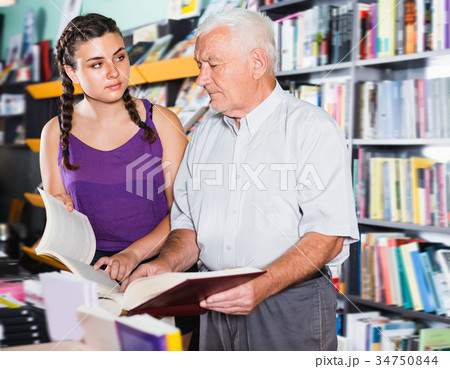 Joyful old man with girl are reading books 34750844