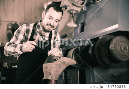 male worker fixing failed shoes in shoe repair workshop 34750858