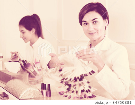 Female manicurist showing lacquer color schemes 34750881