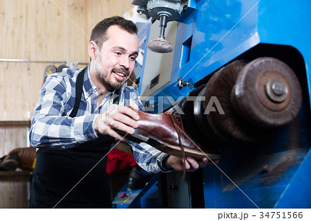 male worker fixing failed shoes in shoe repair workshop 34751566