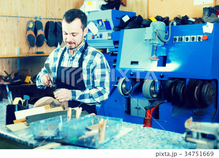 male worker fixing failed shoes in shoe repair workshop male worker fixing failed shoes in shoe repair workshop 34751669